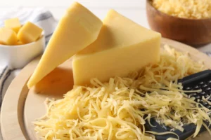 block of cheese next to grated cheese